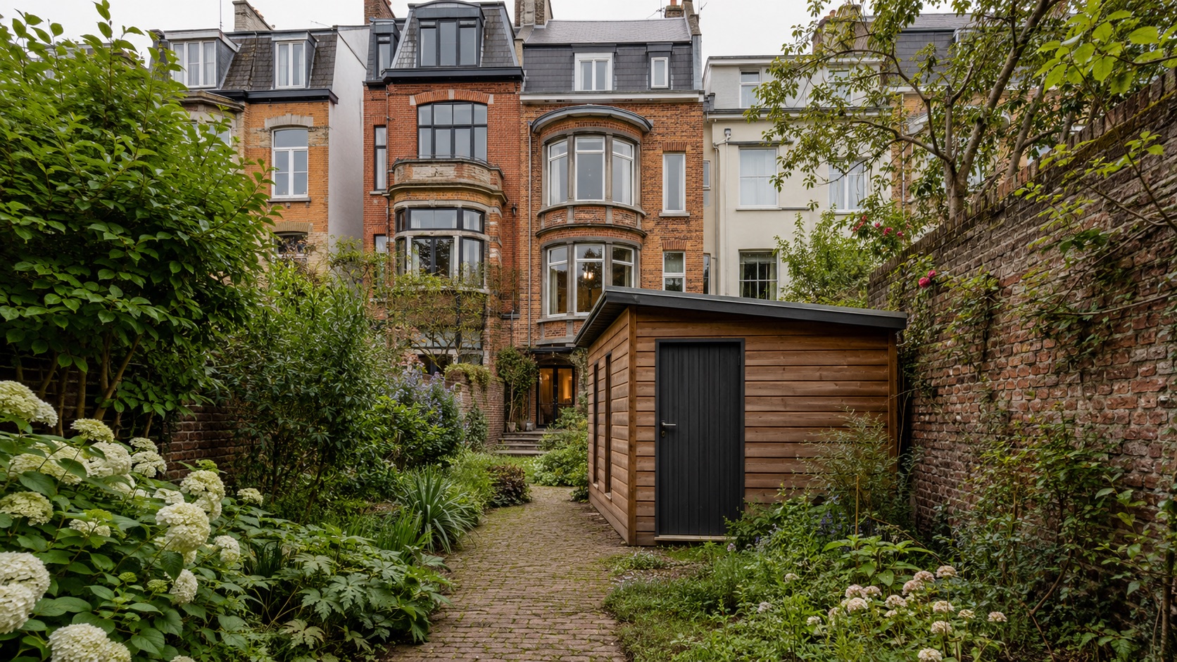 Abri de jardin en bois dans un jardin de ville clos de murs à Bruxelles