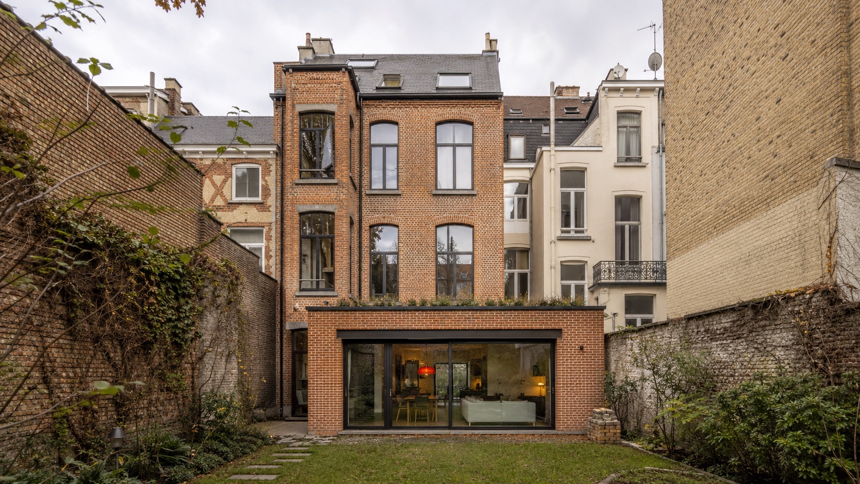 Extension arrière en brique avec grandes baies vitrées d'une maison bruxelloise