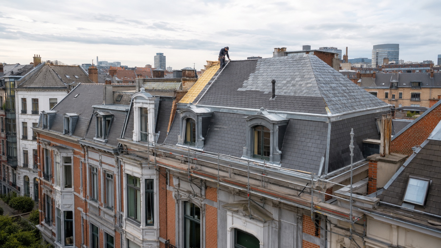 Couvreur remplaçant les ardoises d'une toiture mansardée à Bruxelles